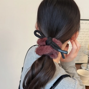 Détail du chouchou en peluche vison synthétique rouge foncé pour coiffures élégantes