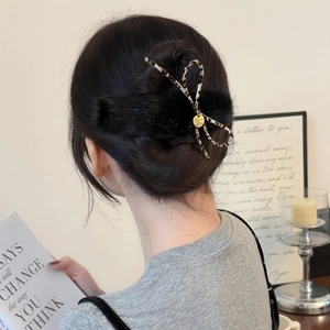 Detail of plush bow hair clip with leopard print and golden tag for elegant hairstyles