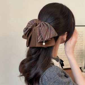 Large vintage paisley floral bow hair claw with pearl pendants shown on a model
