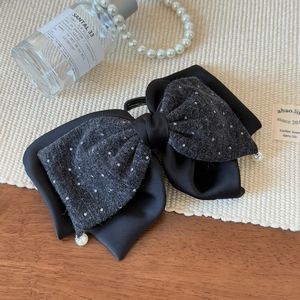 Détail d'une élégante pince à cheveux nœud avec pois blancs et perles de nacre