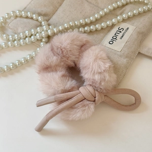 Gros plan détaillé d'un chouchou en peluche rose avec texture douce et perles élégantes