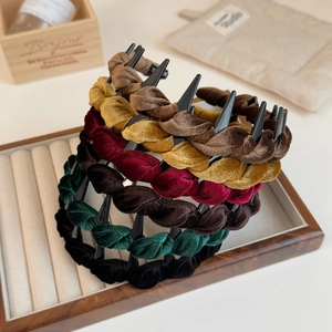 Set of six woven velvet headbands with non-slip teeth in autumn colors on a wooden tray