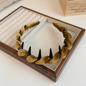 Detail of velvet braided headband with anti-slip inner teeth on wooden display stand