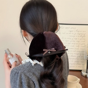 Elegant dark brown velvet bow hair clip shown in a stylish half-up hairstyle