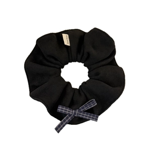 Chouchou en velours noir fait main avec un nœud à carreaux bleu-gris et une étiquette tissée