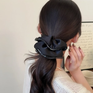 Elegant black satin scrunchie with sparkling sequin edges for women's low ponytail style