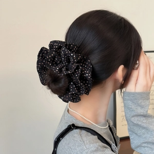 Elegant oversized polka dot scrunchie on high bun hairstyle for a vintage aesthetic