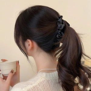 Elegant black satin pleated hair scrunchie shown on a ponytail from a back view