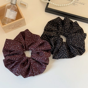 Chic burgundy and black polka dot oversized hair scrunchies on a minimalist desk set