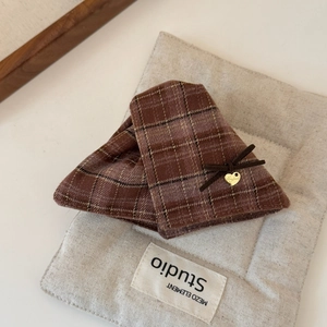 Close-up of brown plaid fabric hair claw with silk bow and golden heart charm detail