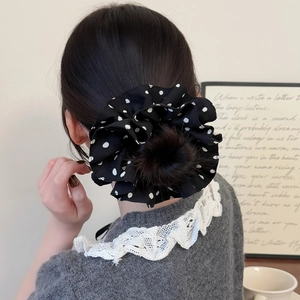 Chouchou rétro noir à pois blancs sur un chignon élégant pour un look vintage