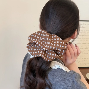 Brown oversized paisley scrunchie with blue and white patterns on a ponytail