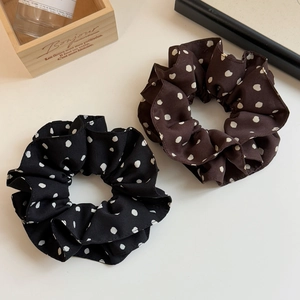 Ensemble de chouchous élégants à pois noir et marron sur un fond blanc neutre