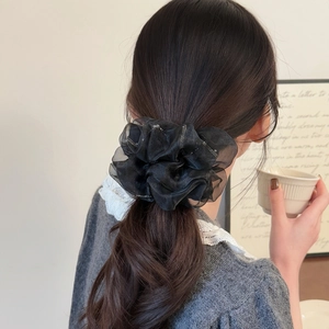 Elegant black pleated organza hair scrunchie with subtle sparkles on a low ponytail