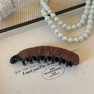 Detail of premium brown fabric wrapped banana hair clip with secure interlocking teeth
