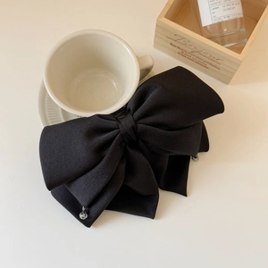 Détail de la pince à cheveux noeud en mousseline noire avec perle de style rétro français