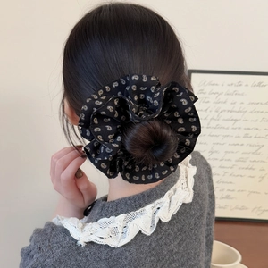 Chouchou géant à motif paisley porté sur un chignon haut pour femmes élégantes