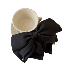 Barrette à cheveux nœud noir élégante avec pendentifs en perles sur fond blanc pur