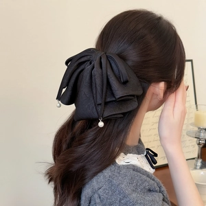 Détail de la pince à cheveux nœud noir avec pampilles de perles pour coiffures chic