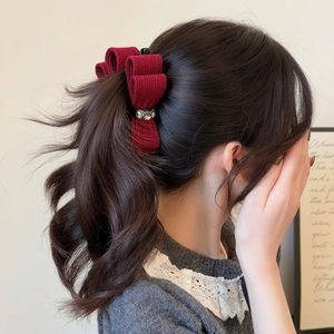 Elegant wine red knit bow hair clip with rhinestone flowers on a model hairstyle