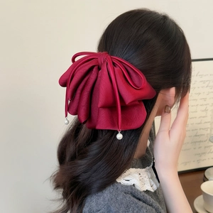 Grande pince à cheveux élégante en satin bordeaux avec pompons perles sur modèle