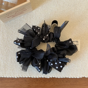 Detail showing sheer black organza and white polka dot satin scrunchie texture