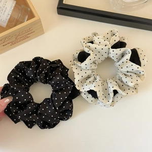 Elegant polka dot scrunchies in black and white satin finish for bun hairstyles