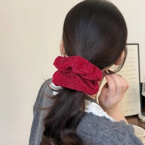 Elegant dark red shimmering knit scrunchie for women shown in a ponytail hairstyle