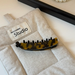 Detailed macro view of a large tortoise shell banana hair clip with secure black plastic teeth