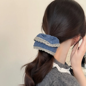Blue and grey knit lace hair scrunchie shown styling a natural long ponytail