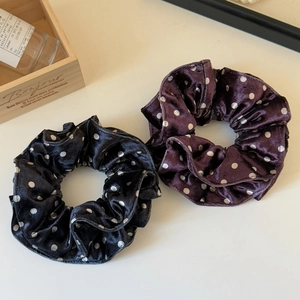 Detail of polka dot velvet scrunchies in black and burgundy with silk-like texture