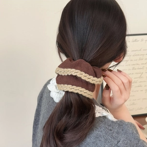 Close-up of a coffee-colored knitted hair scrunchie with beige crochet edge details