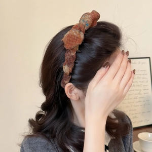 Detail of retro tweed headband showing textured weave and high-volume top padding style
