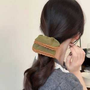 Green knitted scrunchie with brown trim shown on a ponytail with a knit sweater