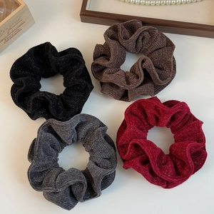 Detail view of 4-piece shimmering knitted scrunchies in black, brown, grey, and burgundy