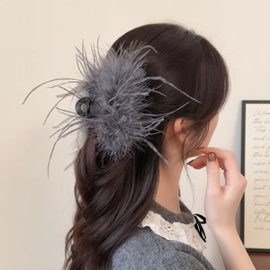 Elegante fermaglio per capelli con piume grigio scuro mostrato su una modella in acconciatura