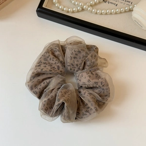 Detail view of leopard print scrunchie featuring dual-layer mesh and organza textures
