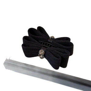 Elegant black knit bow hair claw clip with sparkling rhinestones and glitter fabric detail