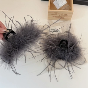 Vista dettagliata di eleganti fermagli per capelli con piume grigie su tavolo bianco