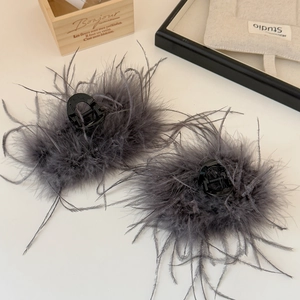 Eleganti mollette per capelli con piume grigie su vassoio in legno per un look raffinato