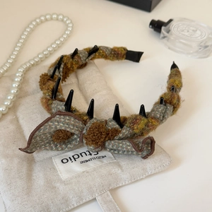 Detail of tweed bow headband with anti-slip teeth in retro autumn and winter style