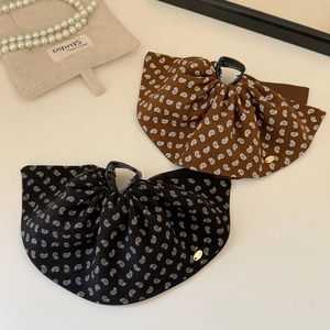 Elegant paisley print fabric hair claws in black and brown with gold logo accents