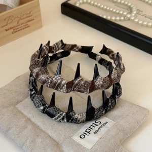 Detail of plaid wool headbands with non-slip teeth and punk style spikes in neutral tones