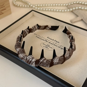 Close-up of retro plaid headband with black stud accents on a warm French vintage background
