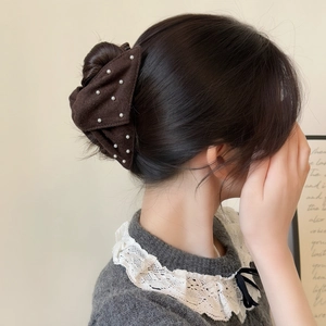Elegant dark brown bow hair claw with pearls shown on model for back-of-head styling