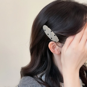 Polka dot oval BB hair clip for women styled on dark curly hair for a side fringe look