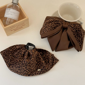 Elegant leopard print bow hair clip and claw set with a golden metallic logo detail