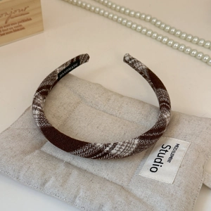 Detailed view of dark brown plaid headband with handmade label and high-quality fabric texture