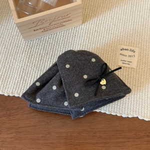 Détail de la pince à cheveux grise à pois avec pendentif cœur et nœud décoratif
