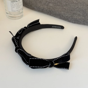 Elegant black velvet headband featuring white stitched bows and gold metal accents